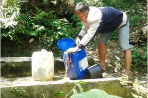 Salah seorang warga saat mengambil air di daerah perbukitan.